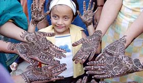 A girl, along with others, shows hennaed hands on the occasion of “Teej” in Amritsar on Sunday.