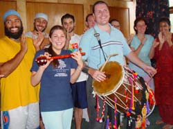 Daisy Rodriguez plays the iktara while Gibb Schreffler strikes the beat on the dhol as others in the background join in. From left: Rahuldeep Singh Gill, Sukhmit Singh Kalsi, Vishal Bhalla, John Warneke, Chester Phillips, Margherita Zorzetto and Amrit Kaur Gill. 
