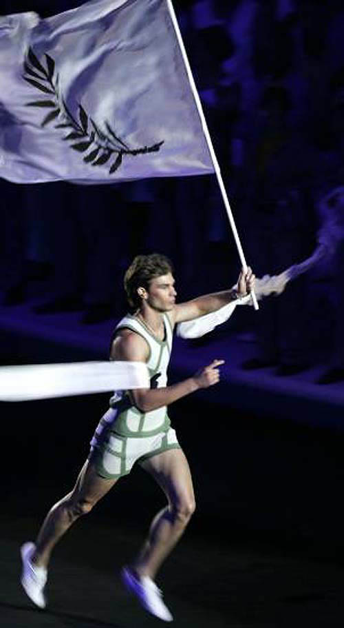 A runner carries a flag bearing the image of an olive branch during the opening ceremony of the Athens 2004 Olympic Games.