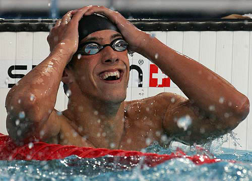 Michael Phelps of the U.S. celebrates after winning the men's 400m individual medley final at the Athens 2004 Olympic Games, August 14, 2004. Phelps won gold with a time of 4.08.26 and set a world record. REUTERS/David Gray