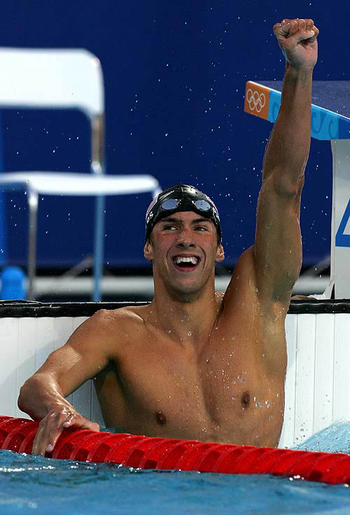 Michael Phelps of the U.S. celebrates after setting a new world record to win the gold medal in the men's 400 metres individual medley final at the Athens 2004 Olympic Games August 14, 2004. Phelps won the event with a time of four minutes 08.26 REUTERS/David Gray