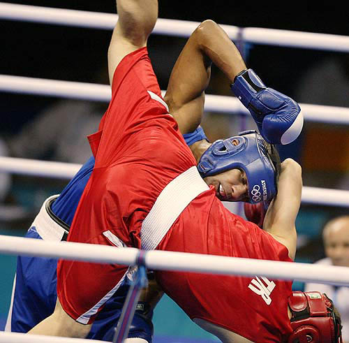 New Zealand's Soulan Pownceby (blue) upends Turkey's Yildirim Ihsan during their 81kg light heavyweight bout at the Periteri Olympic Boxing Hall in Athens, August 14, 2004. Pownceby lost the bout. REUTERS/Nigel Marple