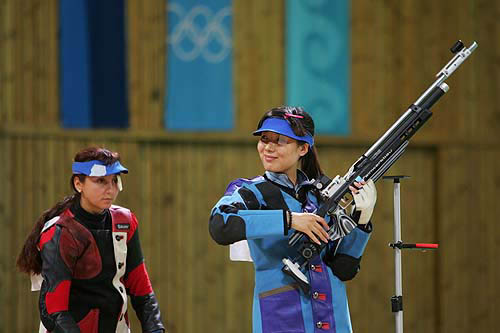 China's Du Li (R) laughs after she won the women's 10 meter air rifle final in Athens, August 14, 2004. Du took gold with a score of 502. Russia's Lioubov Galkina (L) took silver with score of 501.5. REUTERS/Guang Niu