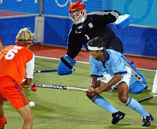 A-DLI 160822 - AUGUST 16, 2004 - ATHENS : India's Adam Sinclair, right, tries to score agaunst Netherlands' goalkeeper Guus Vogels, top, as Floris Evers, right, looks on during their 2004 Olympic Games field hockey match at the Helliniko hockey center in Athens, Greece, Sunday, Aug. 15, 2004. The Netherlands won 3-1. AP/PTI