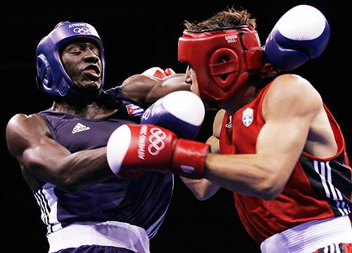 Theodoros Kotakos (R) of Greece and Lorenzo Aragon Armenteros trade punches during their welterweight (69kg) round of 32 Olympic boxing tournament bout at the Athens 2004 Olympic Games August 15, 2004. Armenteros won the fight. REUTERS/Steve Marcus