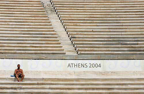 A man enjoys the sun in the Panathinaiko Stadium where archery events are taking place at the Athens 2004 Olympic Games August 15, 2004. REUTERS/Max Rossi
