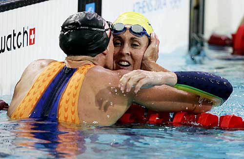 Australia's Petria Thomas (R) is congratulated by Netherlands' Inge de Bruijn (L) after winning the women's 100 metres butterfly final at the Athens 2004 Olympic Games, August 15, 2004. Thomas finished the race in 57.72 seconds. REUTERS/Jerry Lampen