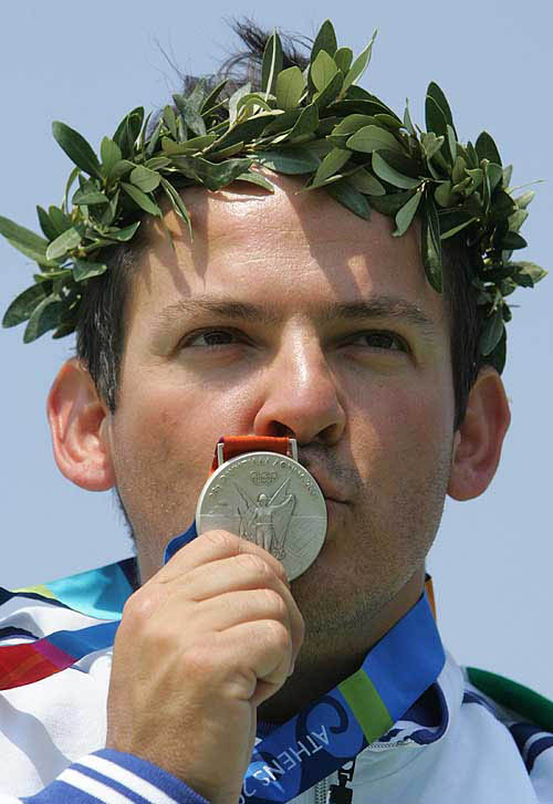Italy's Giovanni Pellielo kisses his silver medal after the medal ceremony for the men's trap final in Athens, August 15, 2004. Pellielo took silver medal with score of 146. REUTERS/Guang Niu