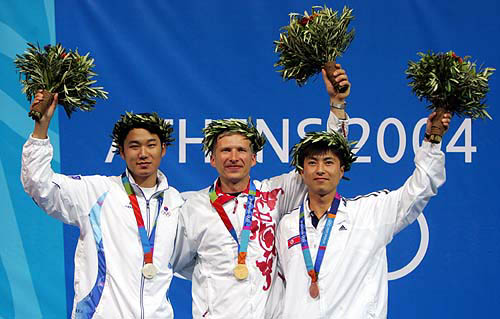 Russia's Olympic marksman Mikhail Nestruev (C) celebrates after he won the Men's 50 meter air pistol in Athens, August 17, 2004. Nestruev took gold with score of 663.3. South Korea's Jin Jong Oh (L) took silver with score of 661.5 and North Korea's Kim Jong Su took bronze with 657.7.  Reuters photo