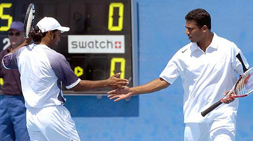 Indian Olympic Tennis doubles team Mahesh Bhuparti, right, and Leander Paes shake hands during their match