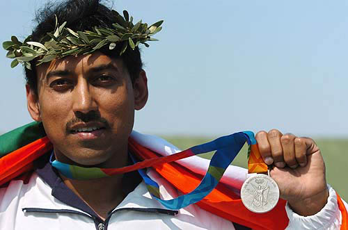 Indian Major Rajyavardhan Singh Rathore shows the silver medal he won in the men's double trap shooting final, on August 17 at the Markopoulo shooting center in Athens.  AFP photo