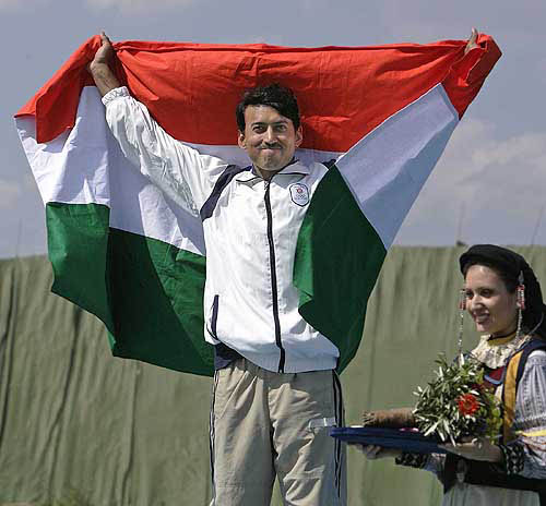 India's Major Rajyavardhan Singh Rathore displays his country's flag as he stands on the podium after the men's double trap finals on Tuesday, August 17, in Athens at the 2004 Summer Olympics. United Arab Emerates's Ahmed Almaktoum won the gold, Rathore won the silver and China's Wang Zheng took the bronze. — AP/PTI photo