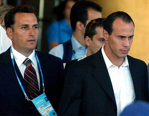 Greek sprinter Kostas Kenteris, right, escorted by his lawyer Michalis Dimitrakopoulos, leaves a central Athenian hotel after he met the IOC executive board, Wednesday, August 18. Greek sprinters Kostas Kenteris and Katerina Thanou withdrew from the Athens Olympic Games, nearly a week after they missed a drug test and were later hospitalized following a suspicious motorcycle crash.  AP/PTI photo