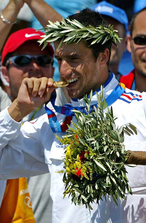 Gold medalist Tony Estanguet of France bites his medal for the photographers following a medal ceremony for the C1 men's canoe single category at the Olympic Canoe-Kayak slalom venue of the Helliniko Sports Complex at the 2004 Olympic Games in Athens, Wednesday, August 18.  AP/PTI photo