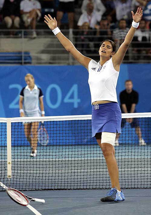 Unseeded Eleni Daniilidou of Greece raises her arms after defeating Magdalena Maleeva of Bulgaria during second round singles tennis action at the 2004 Olympic Games in Athens, Tuesday, August 17. Daniilidou beat Maleeva, 2-6, 6-4, 6-4, despite an injury to her thigh during the match.  AP/PTI photo