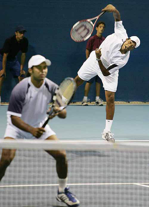 Mahesh Bhupathi of India serves, while doubles partner Leander Paes gets set at the net during their quarterfinal tennis match against Wayne Black and Kevin Ullyett of Zimbabwe at the 2004 Olympic Games in Athens on August 18.