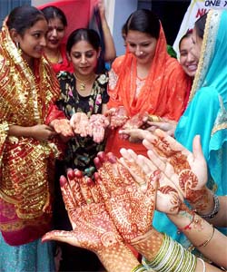 Girls show their hands decorated with mehendi on the occasion of Teej in Patiala on Thursday
