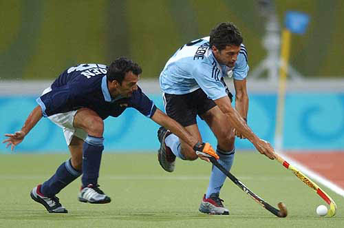 Argentina's Juan Pablo Hourquebie, right, fights for the ball with India's Rasquinha Viren during their 2004 Olympic Games field hockey match in Athens, Greece, on August 23. The final score was 2-2.  AP/PT