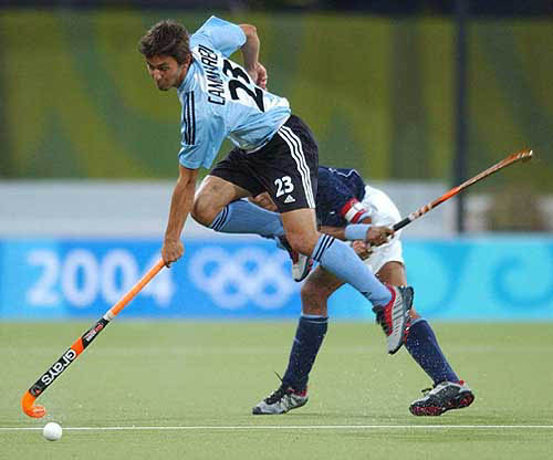 Argentina's Lukas Camareri, top, fights for the ball with India's DilipTirkey during their 2004 Olympic Games field hockey match in Athens, Greece, on August 23.The final score was 2-2.