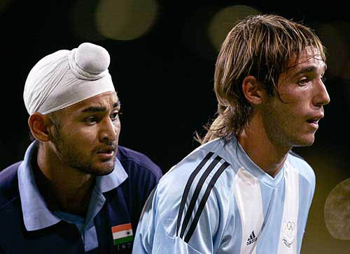India's Sandeep Singh (left) watches Argentina's Matias Paredes at men's field hockey preliminaries at Athens 2004 Olympic Games on August 23. Argentina and India were tied 2-2
