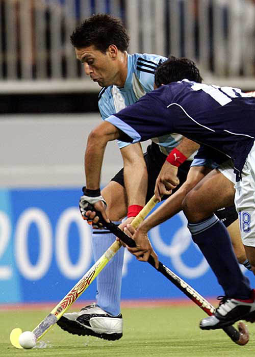 Argentina's Fernando Zylberberg (left) competes for possession with India's Viren Rasquinha at men's field hockey preliminaries at Athens 2004 Olympic Games on August 23. Argentina and India were tied 2-2.