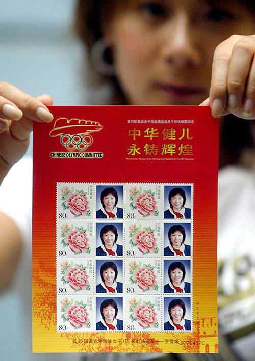A Chinese woman holds up a booklet showing the stamps of 2004 Olympic champion Luo Xuejuan, the gold medallist of the women's 100m breaststroke in Athens, in Hangzhou, Zhejiang eastern China, on August 23. China is for the first time personalizing stamps with each new Chinese Olympic champions since individuals and agencies can apply for customized stamps in China after 2002.