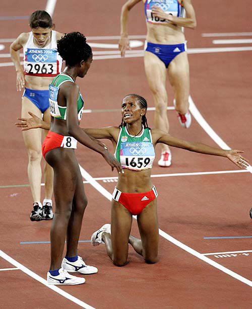 Meseret Defar of Ethiopia (1659) reacts after winning the gold medal in the 5,000 meters as Tirunesh Dibaba of Ethiopa, second left, Yelena Zadorozhnaya of Russia, far left, look on at the Olympic Stadium during the 2004 Olympic Games in Athens on August 23.