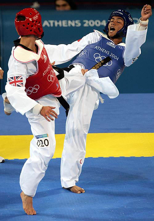 Paul Green (left) of Britain kicks Satriyo Rahadhani of Indonesia during their first round men's under 58kg Taekwondo bout at the Athens 2004 Olympic Games on August 26. Green won the fight.