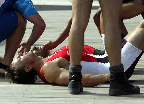 Poland's Michal Sliwinski (in foreground) and Lukasz Woszczynski received assistance after suffering from exhaustion during the men's canoeing C2 1000m final at the Athens 2004 Olympic Games on August 27.