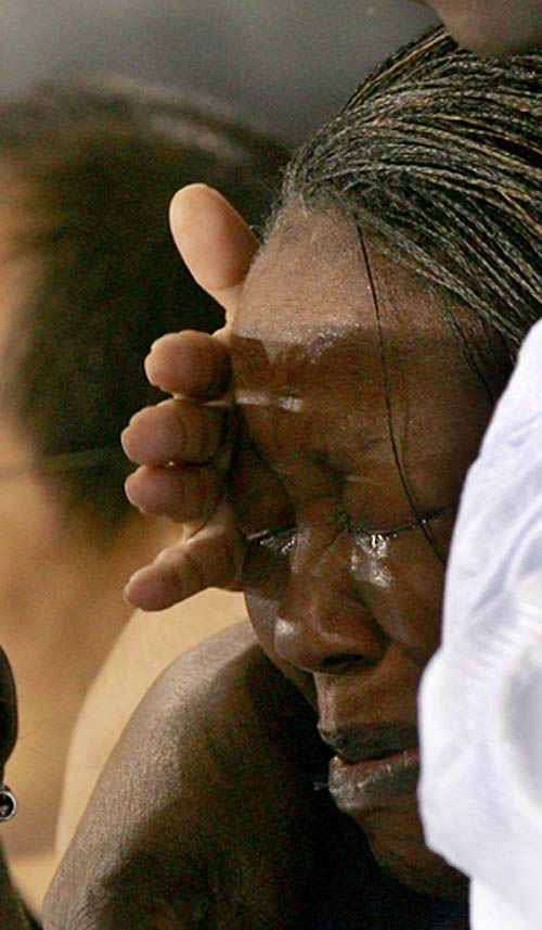 The mother of Bertrand Gbongou Liango (right) of the Central African Republic reacts as he is stretchered away by paramedics after being knocked out by Tuncay Caliskan of Austria during their first round under 69kg taekwondo bout at the Athens 2004 Olympic Games August 27, 2004. The 22-year-old was caught by a sickening reverse round-house kick to the head in his first round match against Austria's Tuncay Caliskan.