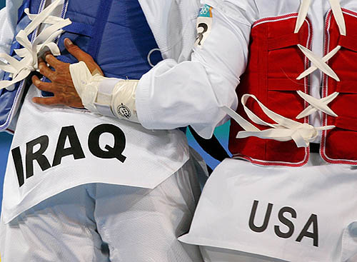 Steven Lopez of the US pats Raid Rasheed of Iraq on the back after their under 80-kg first round taekwondo bout