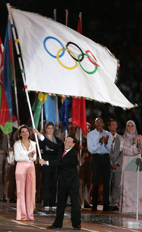 The mayor of Beijing Wang Qishan waves the Olympic flag in front of President of the Athens 2004 Organising Committee for the Olympic Games Gianna Angelopoulos-Daskalaki (L) during the closing ceremony of the Athens 2004 Olympic Games August 29, 2004. The next summer Olympic Games will be held in Beijing in 2008. REUTERS/Mike Blake