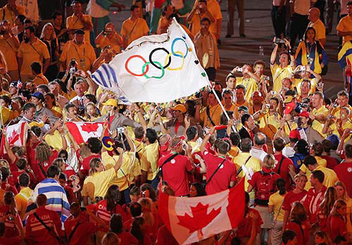 The Mayor of Athens Dora Bakoyannis carries the Olympic flag as she walks among athletes during the closing ceremony of the Athens 2004 Olympic Games August 29, 2004. The next summer Olympic Games will be held in Beijing in 2008. REUTERS/Lucy Nicholson