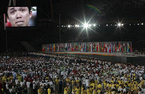 An image of an athlete is projected on to a large screen during the closing ceremony of the Athens 2004 Olympic Games August 29, 2004. The next summer Olympic Games will be held in Beijing in 2008. REUTERS/Arko Datta