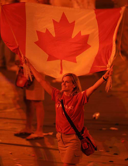 An athlete from Canada waves her national flag during the closing ceremony of the Athens 2004 Olympic Games August 29, 2004. The next summer Olympic Games will be held in Beijing in 2008. REUTERS/Mike Blake