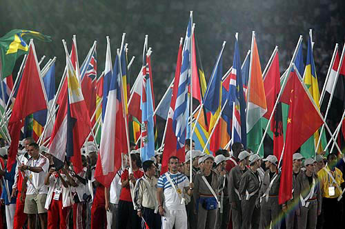 Greece's Pyros Dimas (C blue flag) holds his national flag alongside other athletes during the closing ceremony of the Athens 2004 Olympic Games August 29, 2004. The next summer Olympic Games will be held in Beijing in 2008. REUTERS/Arko Datta