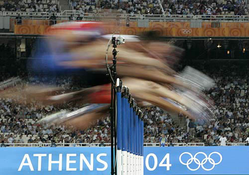 Athletes clear a hurdle during a heat of the men's 110 metres hurdles at the Athens 2004 Olympic Games on August 25.