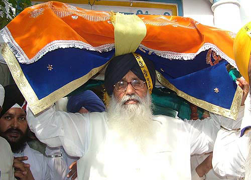 Former Chief Minister and SAD President Parkash Singh Badal carries the holy bir on his