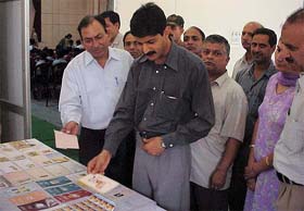 Deputy  Commissioner Devesh Kumar goes through an exhibition of postage stamps in Hamirpur on Tuesday.