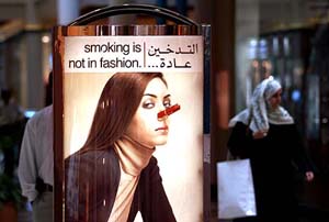 An Arab woman walks behind an anti-smoking poster in a Dubai mall on Wednesday
