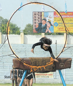 A girl student of Sports School, Rai, performing a fire show at the opening ceremony of the 44th Subroto Cup Football Tournament at Ambedkar Stadium 