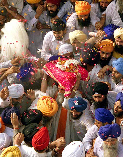 A granthi carries Guru Granth Sahib during a religious procession