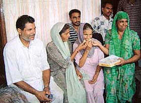 Kishni Devi, mother of Tilak Raj, is given sweets after getting the news about the release of her son in Iraq