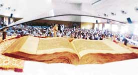 Devotees pay obeisance to an old handwritten Guru Granth Sahib on Parkash Utsav in the college