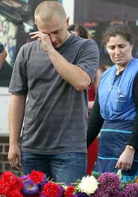 A Muscovite wipes tears as he lays flowers at the site of an explosion in Moscow