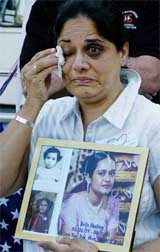 Indira Bhukhau, a member of the WTC Families for Proper Burial, cries as she displays a picture of her daughter Bella who died in the WTC attacks, at the ground zero rally in New York City on Wednesday. 