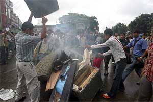 People gather around an area burnt by rioters in the Wednesday violence in Kathmandu, Nepal.  