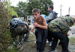 A boy runs for cover after he was released from the school seized by heavily armed masked men and women in the town of Beslan in North Ossetia province. Russian soldiers battled Chechen separatists to end a two-day-old school siege. 