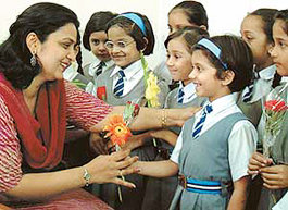 tiny tots of a school present flowers to their teacher 