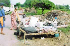 Narain Singh and his wife with their household goods thrown on the road by their landlord in Mattewara village